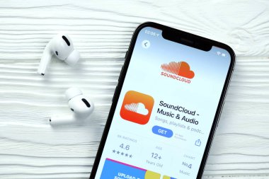 KHARKOV, UKRAINE - 5 Mart 2021: Soundcloud simgesi ve uygulaması iPhone 12 profesyonel ekranda beyaz ahşap masadaki uçak podları profosyoneli