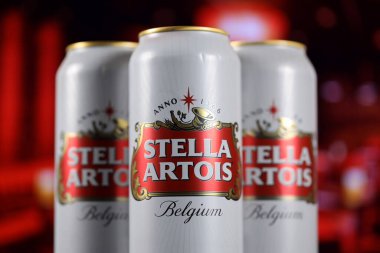 KHARKOV, UKRAINE - 14 Şubat 2021: Stella Artois bira kutuları ahşap masa üzerinde arka planda kırmızı çubuk ile. Alkol üretimi