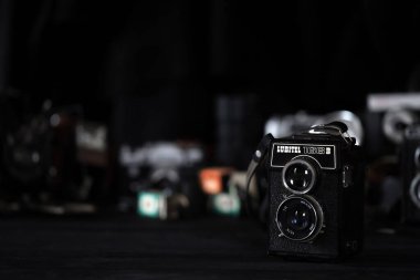 KHARKOV, UKRAINE - 27 Nisan 2021: Lubitel 166b ve 2 Film kamerası ve fotoğrafçı karanlık odasındaki siyah ahşap masada eski bir fotoğraf makinesi. Sovyetler Birliği zamanından fotoğraf malzemeleri.