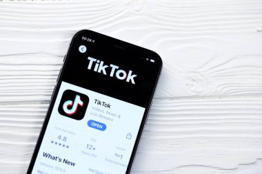 KHARKOV, UKRAINE - 5 Mart 2021: Tiktok simgesi ve uygulaması iPhone 12 'de beyaz ahşap masadaki profesyonel ekranda