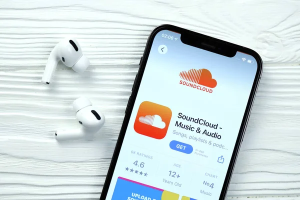 KHARKOV, UKRAINE - 5 Mart 2021: Soundcloud simgesi ve uygulaması iPhone 12 profesyonel ekranda beyaz ahşap masadaki uçak podları profosyoneli