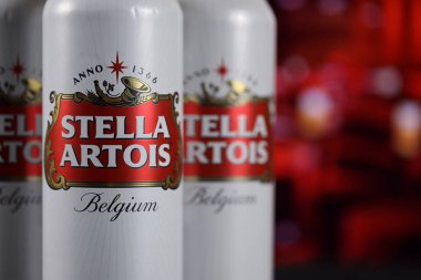 KHARKOV, UKRAINE - 14 Şubat 2021: Stella Artois bira kutuları ahşap masa üzerinde arka planda kırmızı çubuk ile. Alkol üretimi
