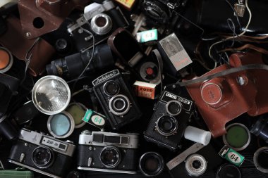 KHARKOV, UKRAINE - 27 Nisan 2021: Fotoğraf makineleri ve fotoğrafçı karanlık odasındaki siyah ahşap masada eski bir fotoğraf makinesi. Sovyetler Birliği zamanından fotoğraf malzemeleri.