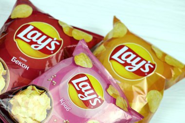 KHARKOV, UKRAINE - 3 HAZİRAN 2021: Ahşap zemin üzerinde lay 's patates cipsi çeşitli aromalı. Lay 's 1965' ten beri PepsiCo tarafından Frito-Lay 'e ait.