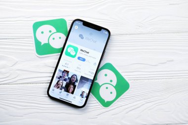 KHARKOV, UKRAINE - 5 Mart 2021: İPhone 12 'deki Uygulama mağazasından gelen kurye simgesi ve uygulaması beyaz ahşap masadaki profesyonel ekranda