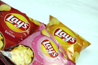 KHARKOV, UKRAINE - 3 HAZİRAN 2021: Ahşap zemin üzerinde lay 's patates cipsi çeşitli aromalı. Lay 's 1965' ten beri PepsiCo tarafından Frito-Lay 'e ait.
