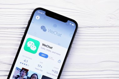 KHARKOV, UKRAINE - 5 Mart 2021: İPhone 12 'deki Uygulama mağazasından gelen kurye simgesi ve uygulaması beyaz ahşap masadaki profesyonel ekranda