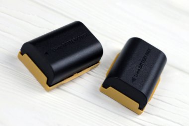 KHARKOV, UKRAINE - 14 Mart 2021: Beyaz tahta masa üzerinde modern DSLR fotoğraf makineleri için Kastar lityum iyonu veya li-ion şarj edilebilir piller