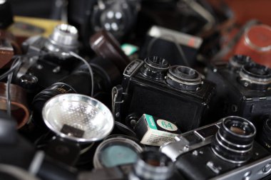 KHARKOV, UKRAINE - 27 Nisan 2021: Fotoğraf makineleri ve fotoğrafçı karanlık odasındaki siyah ahşap masada eski bir fotoğraf makinesi. Sovyetler Birliği zamanından fotoğraf malzemeleri.