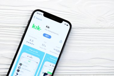 KHARKOV, UKRAINE - 5 Mart 2021: Kik simgesi ve uygulaması iPhone 12 'den beyaz ahşap masadaki profesyonel ekranda