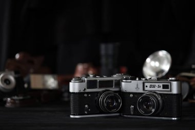 KHARKOV, UKRAINE - 27 Nisan 2021: Fed 4 ve 5b Film fotoğraf makinesi ve fotoğrafçı karanlık odasındaki siyah ahşap masada eski bir fotoğraf makinesi. Sovyetler Birliği zamanından fotoğraf malzemeleri.