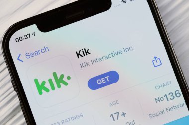 KHARKOV, UKRAINE - 5 Mart 2021: Kik simgesi ve uygulaması iPhone 12 'den beyaz ahşap masadaki profesyonel ekranda