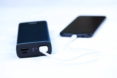 KHARKOV, UKRAINE - 14 Mart 2021: Xipin güç bankası şarj cihazı Mikro USB kablo bağlantısıyla Samsung akıllı telefonuna bağlandı