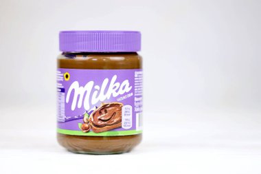 KHARKOV, UKRAINE - 2 Temmuz 2021: Beyaz ahşap masa üzerinde klasik leylak rengi tasarımı ile yayılmış Milka tatlandırılmış fındık kakaosu kutusu