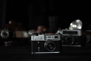 KHARKOV, UKRAINE - 27 Nisan 2021: Fed 4 ve 5b Film fotoğraf makinesi ve fotoğrafçı karanlık odasındaki siyah ahşap masada eski bir fotoğraf makinesi. Sovyetler Birliği zamanından fotoğraf malzemeleri.