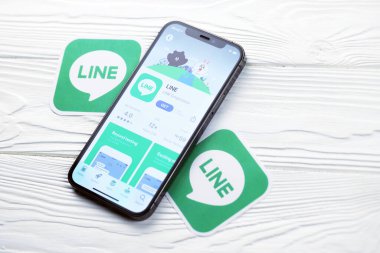KHARKOV, UKRAINE - 5 Mart 2021: İnternet kurye simgesi ve uygulaması iPhone 12 'den beyaz ahşap masadaki profesyonel ekranda