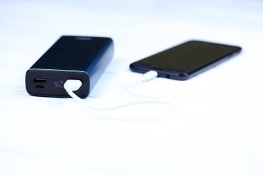 KHARKOV, UKRAINE - 14 Mart 2021: Xipin güç bankası şarj cihazı Mikro USB kablo bağlantısıyla Samsung akıllı telefonuna bağlandı