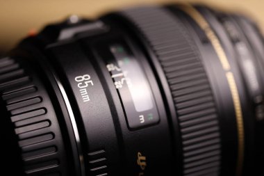 KHARKOV, UKRAINE - 21 Ocak 2021: Siyah kumaş zemin üzerinde Canon EF 85mm 1.8 lens. Canon marka ürününün ayrıntılı fotoğrafı