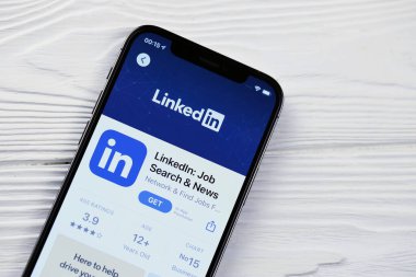 KHARKOV, UKRAINE - 5 Mart 2021: Beyaz ahşap masadaki iPhone 12 profesyonel ekranda Uygulama mağazasından gelen Linkedin simgesi ve uygulaması
