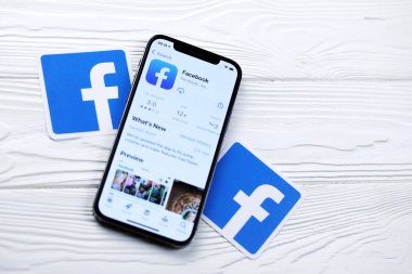 KHARKOV, UKRAINE - 5 Mart 2021: Facebook simgesi ve uygulaması iPhone 12 'den beyaz ahşap masadaki profesyonel ekranda