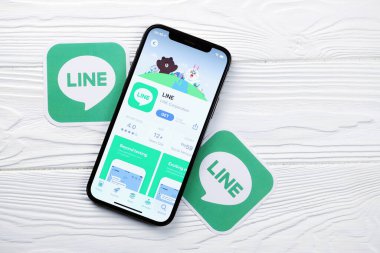 KHARKOV, UKRAINE - 5 Mart 2021: İnternet kurye simgesi ve uygulaması iPhone 12 'den beyaz ahşap masadaki profesyonel ekranda