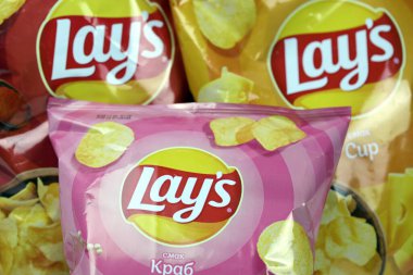 KHARKOV, UKRAINE - 3 HAZİRAN 2021: Ahşap zemin üzerinde lay 's patates cipsi çeşitli aromalı. Lay 's 1965' ten beri PepsiCo tarafından Frito-Lay 'e ait.