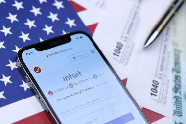 KHARKOV, UKRAINE - 5 Mart 2021: Turbotax sezgi web sitesi iPhone 12 profesyonel ekranda 1040 ve w-2 ABD bayrağında kağıt vergi formları