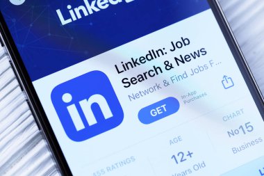 KHARKOV, UKRAINE - 5 Mart 2021: Beyaz ahşap masadaki iPhone 12 profesyonel ekranda Uygulama mağazasından gelen Linkedin simgesi ve uygulaması
