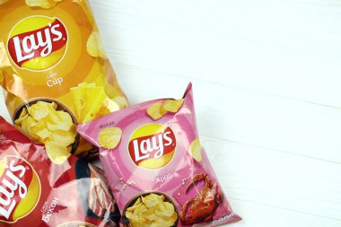 KHARKOV, UKRAINE - 3 HAZİRAN 2021: Ahşap zemin üzerinde lay 's patates cipsi çeşitli aromalı. Lay 's 1965' ten beri PepsiCo tarafından Frito-Lay 'e ait.