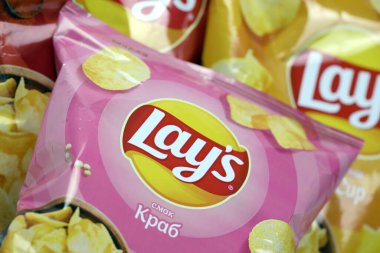 KHARKOV, UKRAINE - 3 HAZİRAN 2021: Ahşap zemin üzerinde lay 's patates cipsi çeşitli aromalı. Lay 's 1965' ten beri PepsiCo tarafından Frito-Lay 'e ait.