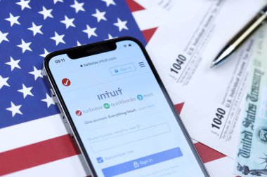 KHARKOV, UKRAINE - 5 Mart 2021: Turbotax sezgi web sitesi iPhone 12 profesyonel ekranda 1040 ve w-2 ABD bayrağında kağıt vergi formları