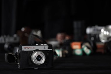 KHARKOV, UKRAINE - 27 Nisan 2021: Smena 8 metre fotoğraf makinesi ve fotoğrafçı karanlık odasındaki siyah ahşap masada eski bir fotoğraf makinesi. Sovyetler Birliği zamanından fotoğraf malzemeleri.