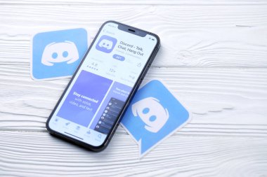 KHARKOV, UKRAINE - 5 Mart 2021: Uygulama mağazasından alınan simge ve uygulama beyaz ahşap masadaki iPhone 12 profesyonel ekranda