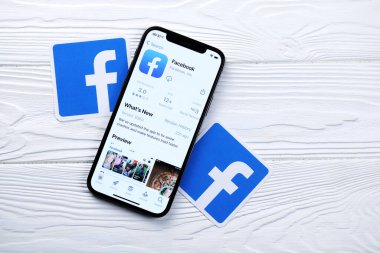 KHARKOV, UKRAINE - 5 Mart 2021: Facebook simgesi ve uygulaması iPhone 12 'den beyaz ahşap masadaki profesyonel ekranda