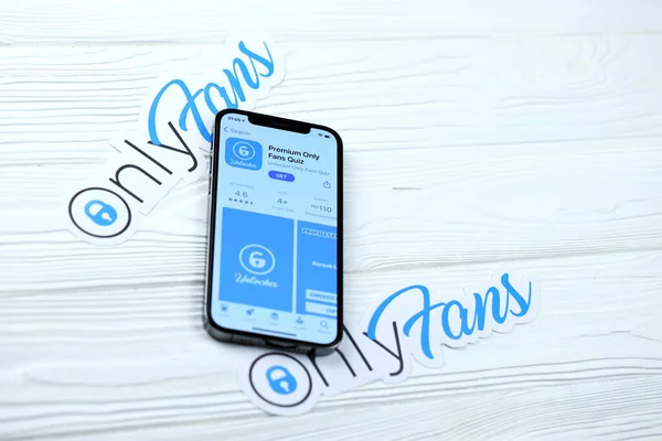 KHARKOV, UKRAINE - 5 Mart 2021: Onlyfan simgesi ve uygulaması iPhone 12 'den beyaz ahşap masadaki profesyonel ekranda