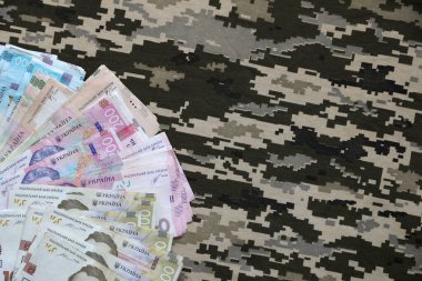 Ukrayna hrivnya 'sı Ukrayna askeri piksel kamuflajlı kumaş dokusuna sahip. Gri, kahverengi ve yeşil pikselli kamuflaj desenli kumaş. Ukrayna askerlerinin resmi üniforması yaklaşıyor.