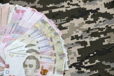 Ukrayna hrivnya 'sı Ukrayna askeri piksel kamuflajlı kumaş dokusuna sahip. Gri, kahverengi ve yeşil pikselli kamuflaj desenli kumaş. Ukrayna askerlerinin resmi üniforması yaklaşıyor.