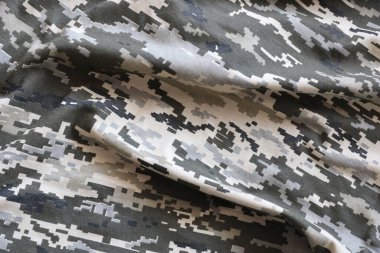 Ukrayna askeri piksel kamuflaj dokusuna sahip kumaş. Gri, kahverengi ve yeşil pikselli kamuflaj desenli kumaş. Ukrayna askerlerinin resmi üniforması yaklaşıyor.