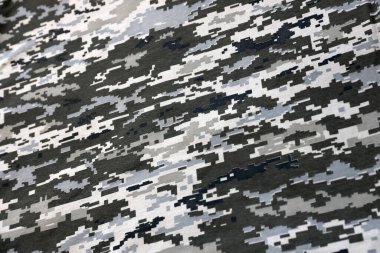 Ukrayna askeri piksel kamuflaj dokusuna sahip kumaş. Gri, kahverengi ve yeşil pikselli kamuflaj desenli kumaş. Ukrayna askerlerinin resmi üniforması yaklaşıyor.