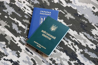 Ukrayna askeri kimliği ve piksel kamuflaj dokusuna sahip yabancı pasaport. Gri, kahverengi ve yeşil pikselli kamuflaj desenli kumaş Ukrayna ordusuna ait kişisel jeton ve pasaport..