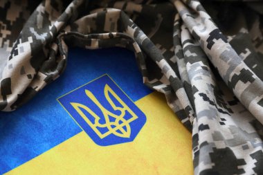 Ukrayna bayrağı ve piksel kamuflajlı kumaşlı arma. Gri, kahverengi ve yeşil pikselli kamuflaj desenli kumaş Ukrayna mızrak işaretli..