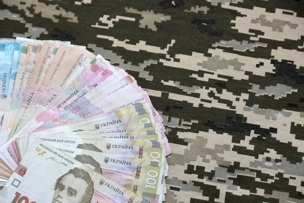 Ukrayna hrivnya 'sı Ukrayna askeri piksel kamuflajlı kumaş dokusuna sahip. Gri, kahverengi ve yeşil pikselli kamuflaj desenli kumaş. Ukrayna askerlerinin resmi üniforması yaklaşıyor.