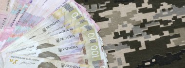 Ukrayna hrivnya 'sı Ukrayna askeri piksel kamuflajlı kumaş dokusuna sahip. Gri, kahverengi ve yeşil pikselli kamuflaj desenli kumaş. Ukrayna askerlerinin resmi üniforması yaklaşıyor.