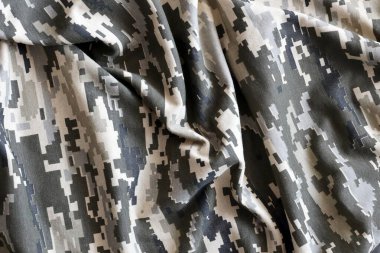 Ukrayna askeri piksel kamuflaj dokusuna sahip kumaş. Gri, kahverengi ve yeşil pikselli kamuflaj desenli kumaş. Ukrayna askerlerinin resmi üniforması yaklaşıyor.