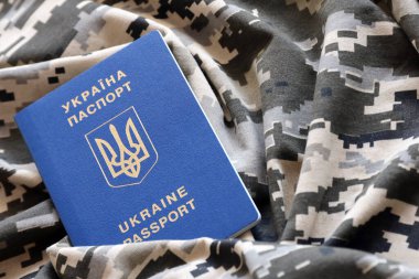 Askeri kamuflajlı kumaş dokusunda Ukrayna pasaportu. Gri, kahverengi ve yeşil pikselli kamuflaj desenli kumaş ve Ukrayna kimlik kartı.
