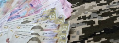 Ukrayna hrivnya 'sı Ukrayna askeri piksel kamuflajlı kumaş dokusuna sahip. Gri, kahverengi ve yeşil pikselli kamuflaj desenli kumaş. Ukrayna askerlerinin resmi üniforması yaklaşıyor.