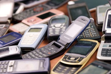 KHARKIV, UKRAINE - 16 Aralık 2021: 90 'lardan 2000' lere kadar kullanılmış eski cep telefonları. Elektronik ürünleri piyasada ucuza geri dönüştürme
