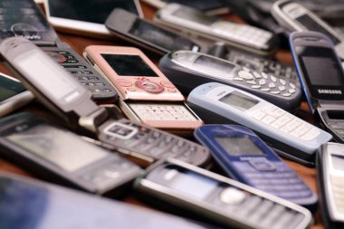 KHARKIV, UKRAINE - 16 Aralık 2021: 90 'lardan 2000' lere kadar kullanılmış eski cep telefonları. Elektronik ürünleri piyasada ucuza geri dönüştürme