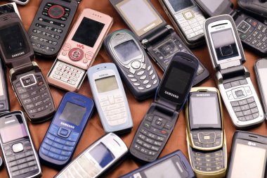 KHARKIV, UKRAINE - 16 Aralık 2021: 90 'lardan 2000' lere kadar kullanılmış eski cep telefonları. Elektronik ürünleri piyasada ucuza geri dönüştürme