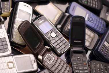 KHARKIV, UKRAINE - 16 Aralık 2021: 90 'lardan 2000' lere kadar kullanılmış eski cep telefonları. Elektronik ürünleri piyasada ucuza geri dönüştürme
